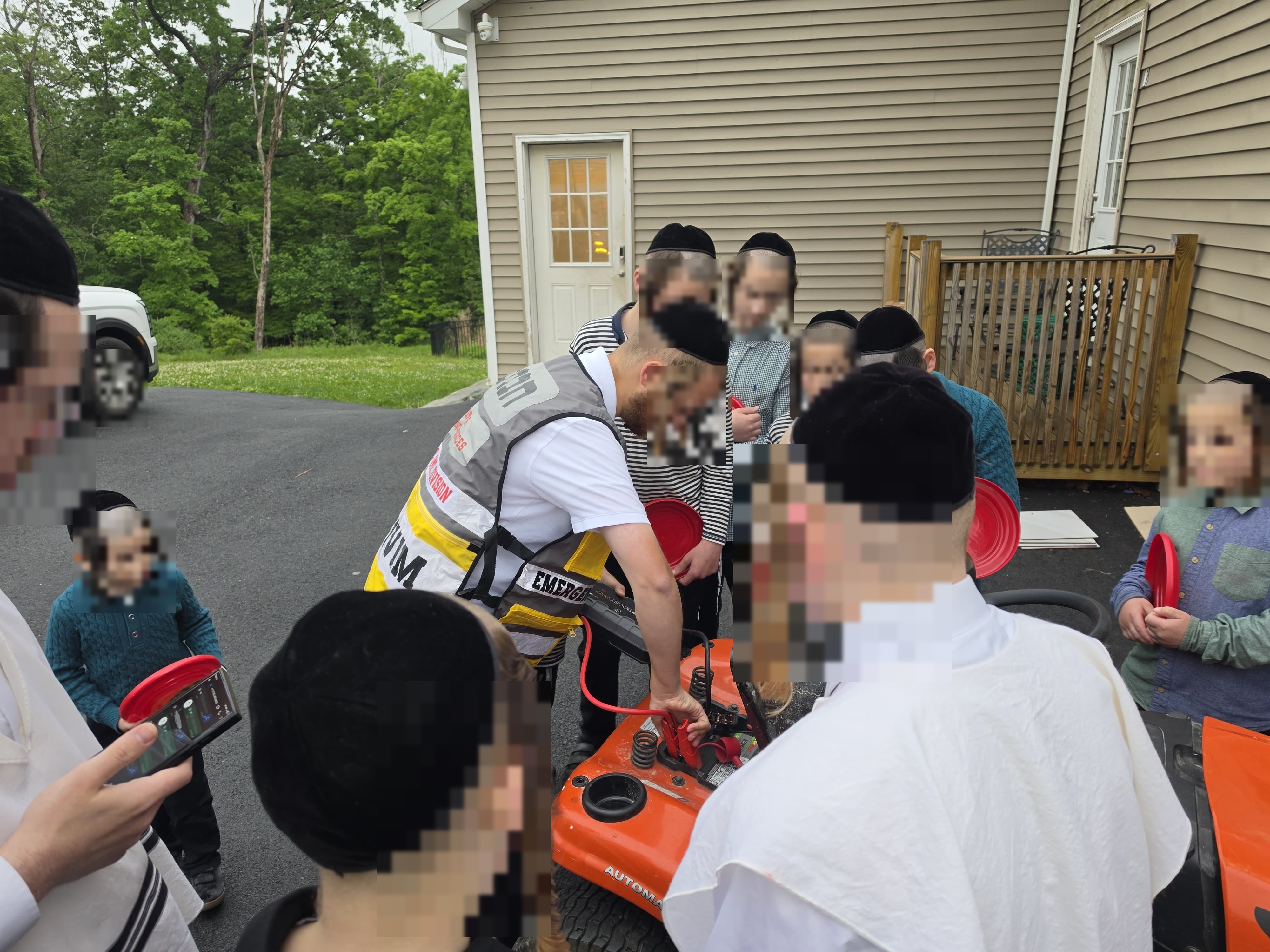 A Chavivim member showing children a piece of response equipment up close during the Achyim B'Yachad outing