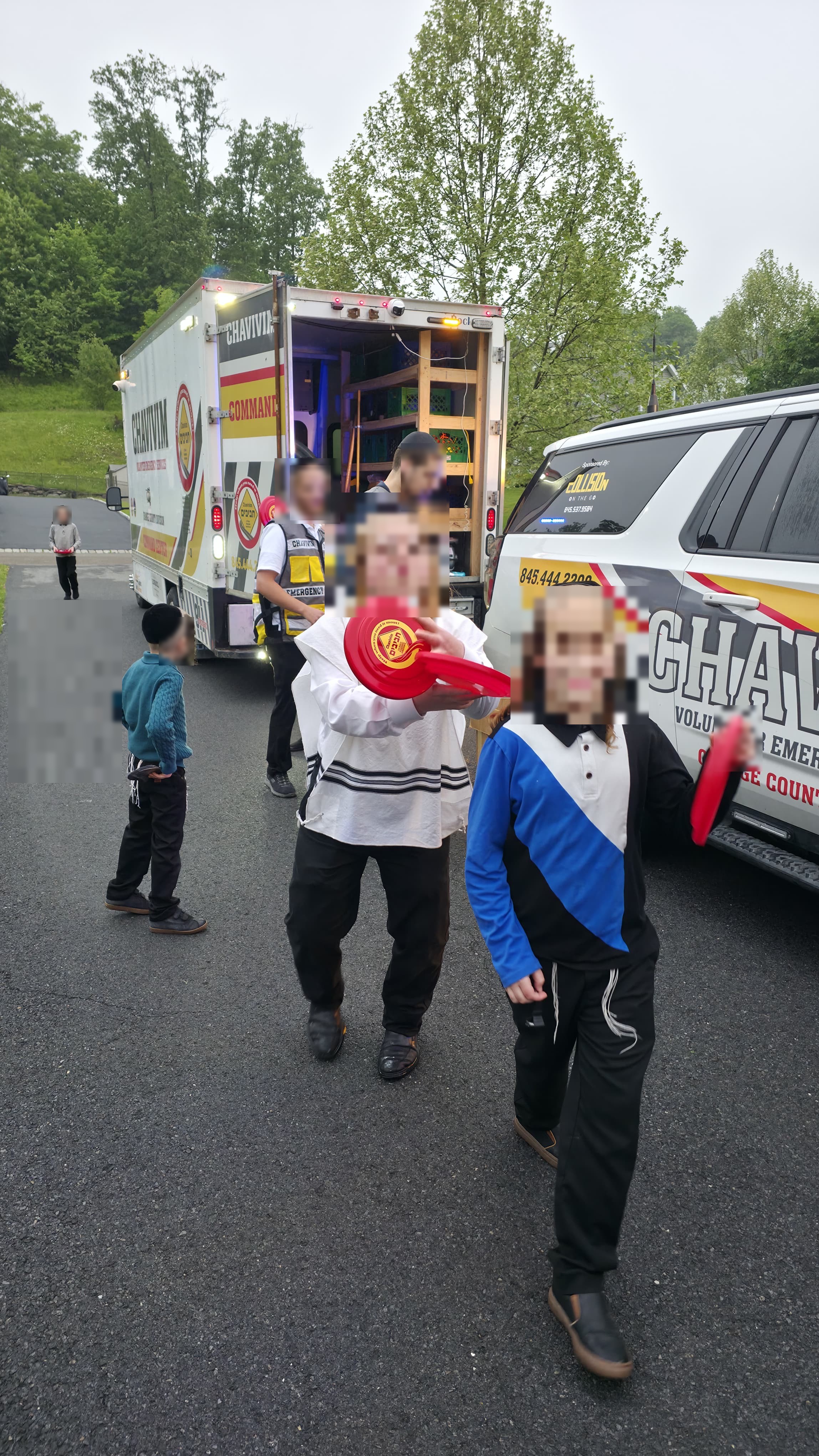 Children walking with their new frisbees as the KJ-500 Command Center and KJ-501 fly car sit behind them