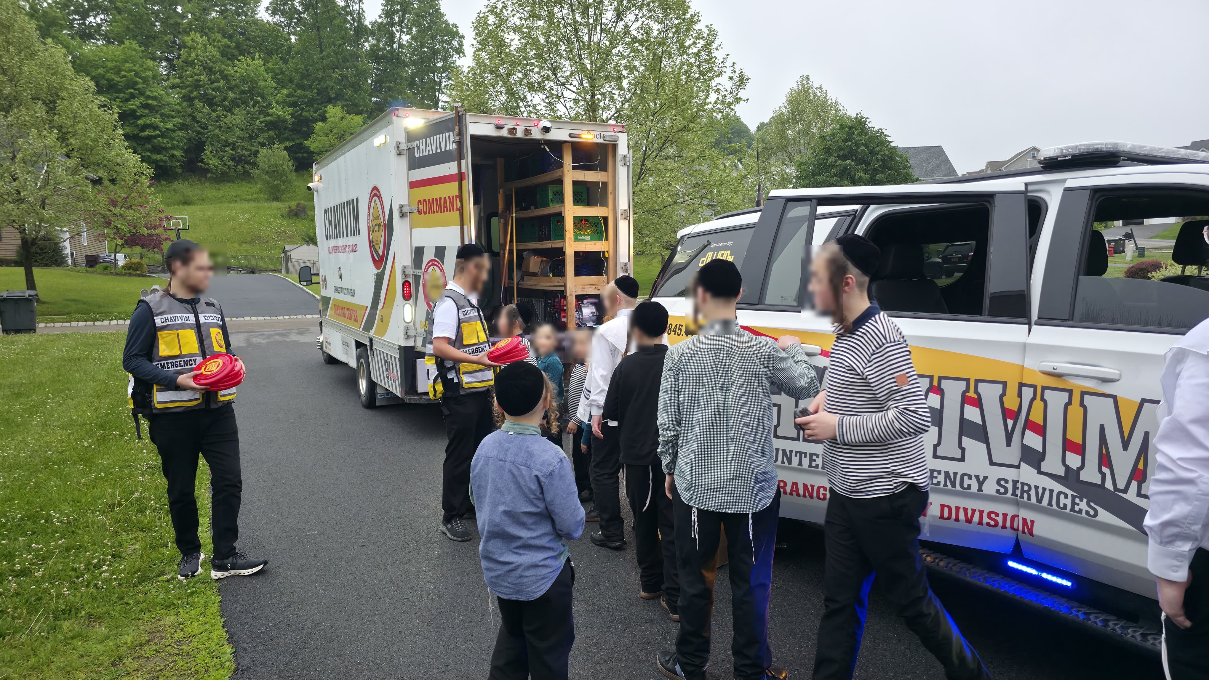 Orange County Chavivim members showing children from Achyim B'Yachad of Chai Lifeline the KJ-500 Command Center truck and the KJ-501 fly car