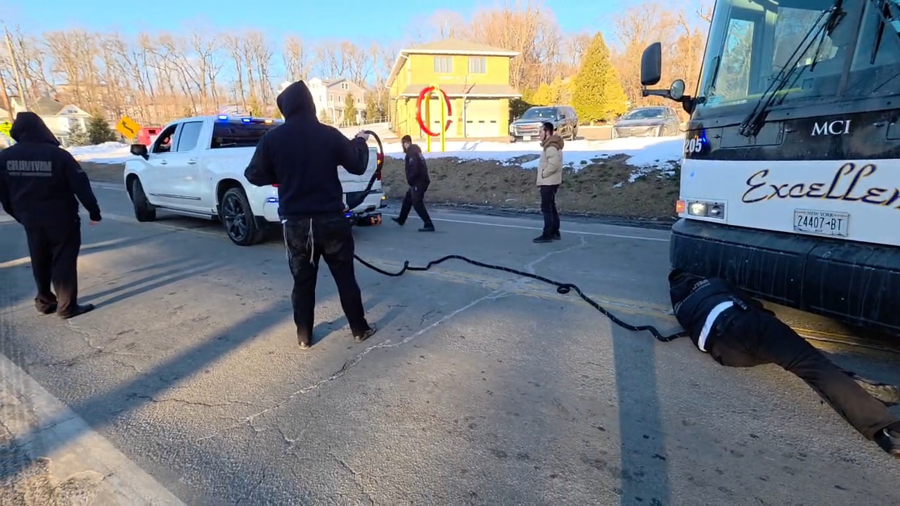 Chavivim members threading the tow rope from the truck to the front of the stuck bus