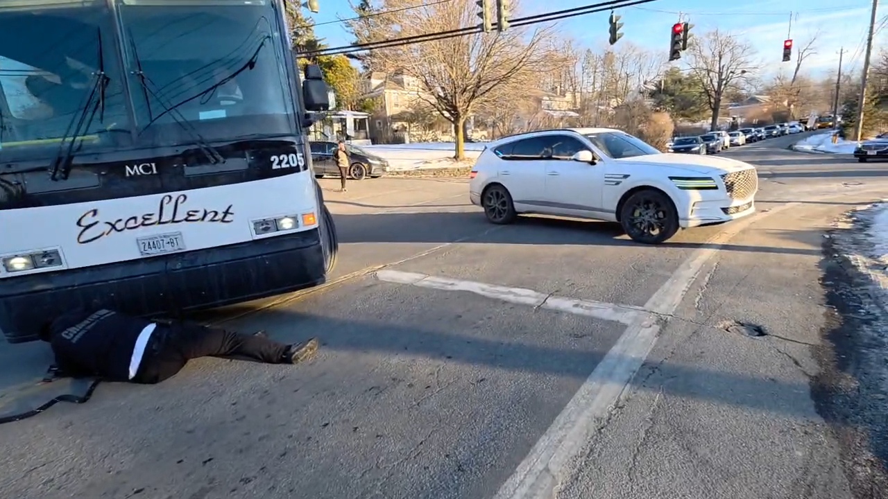 Excellent Bus Lines coach stuck at the intersection of Schunnemunk Road and Route 208, with a Chavivim member underneath rigging a tow line