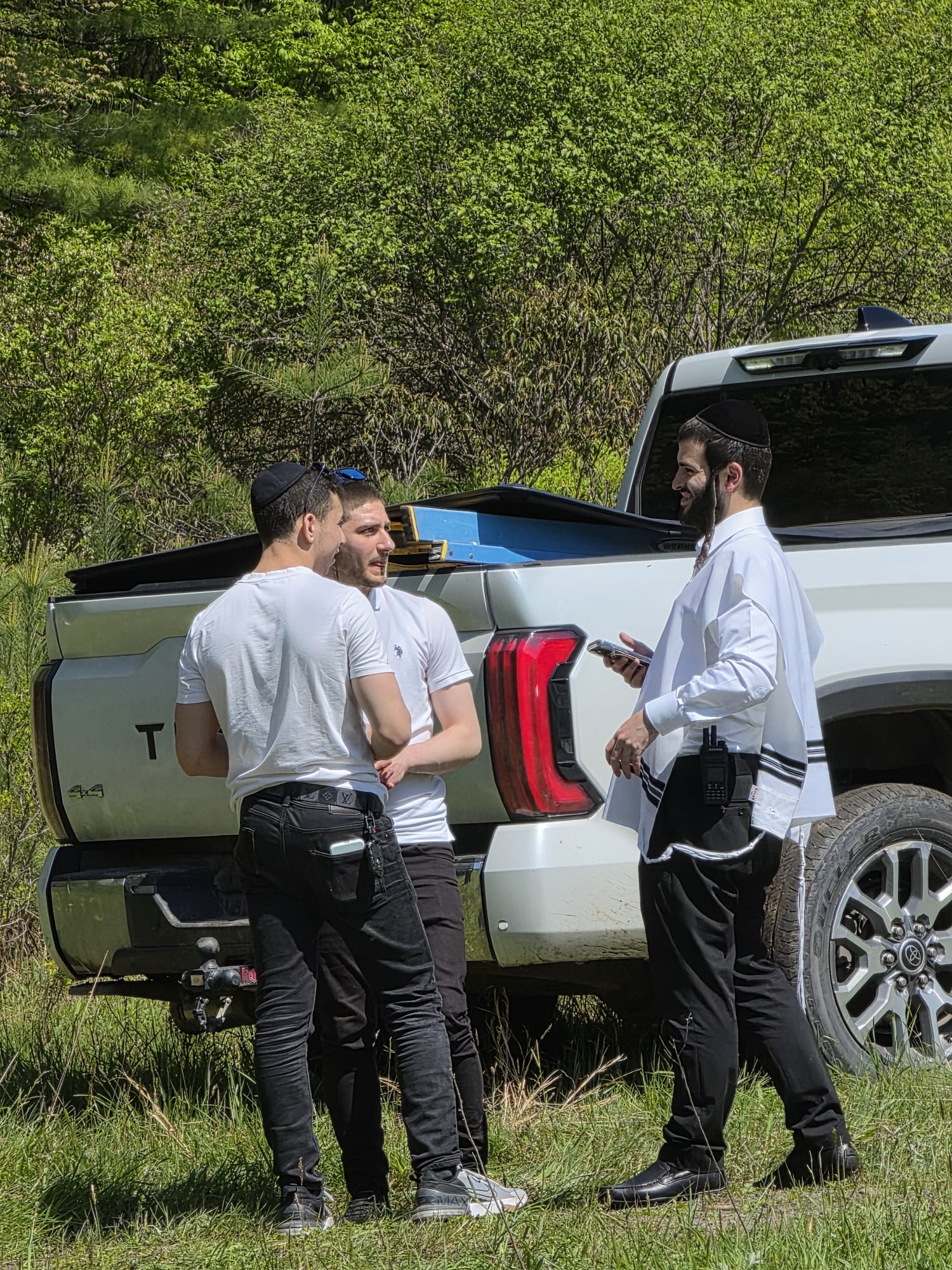 Chavivim members in a briefing at the back of a response truck in wooded terrain