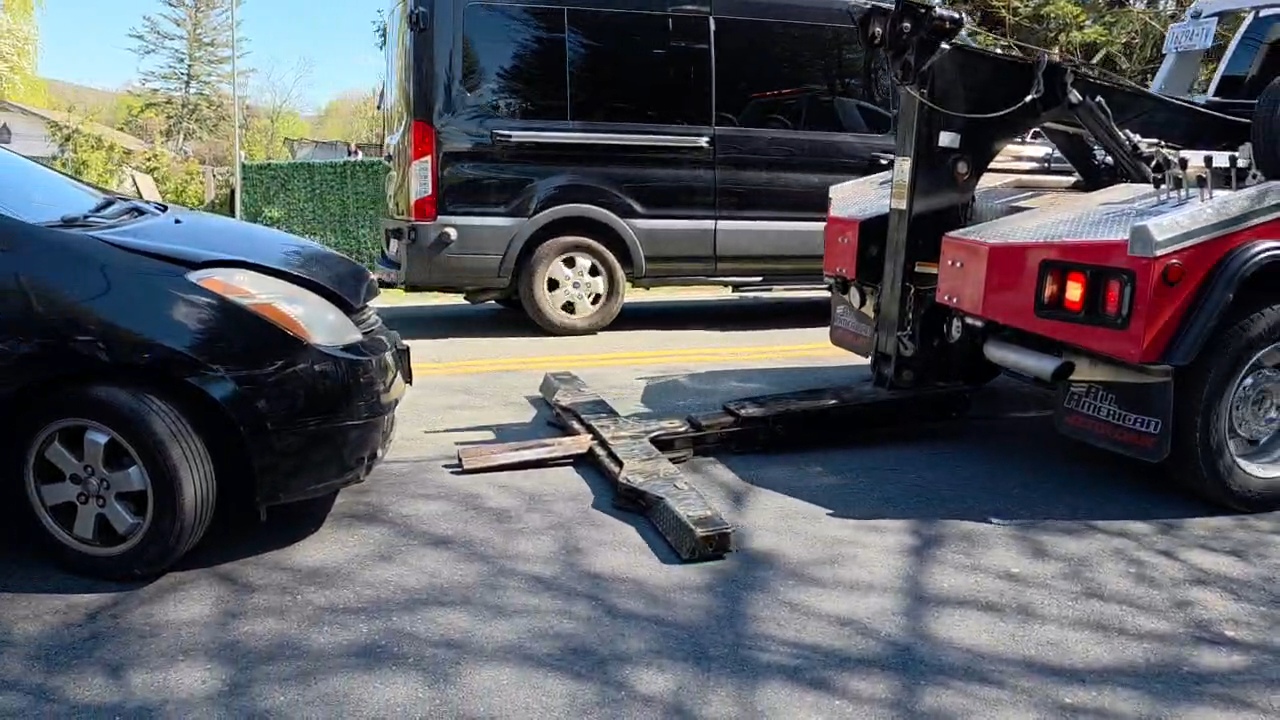 Tow truck hooking up to the stalled car on CR 105