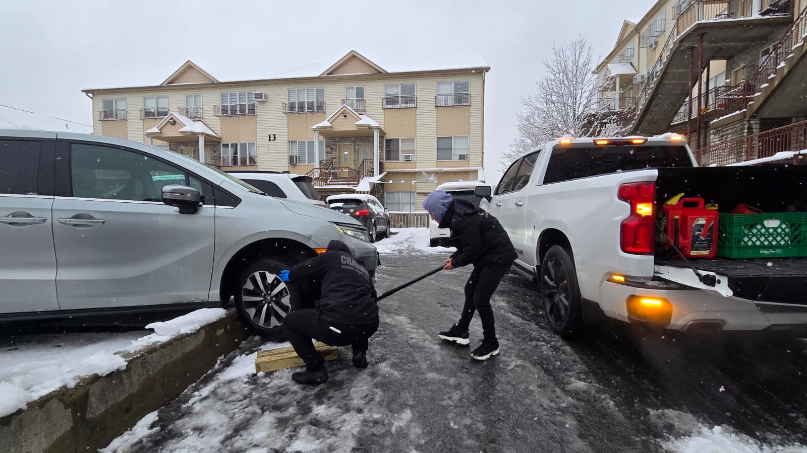 Two Chavivim members working together to free the vehicle from the curb in the snow