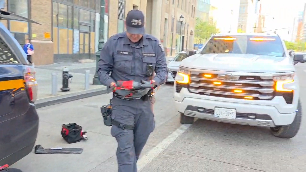 Chavivim member carrying Milwaukee impact tools on the Manhattan sidewalk with the response truck behind him