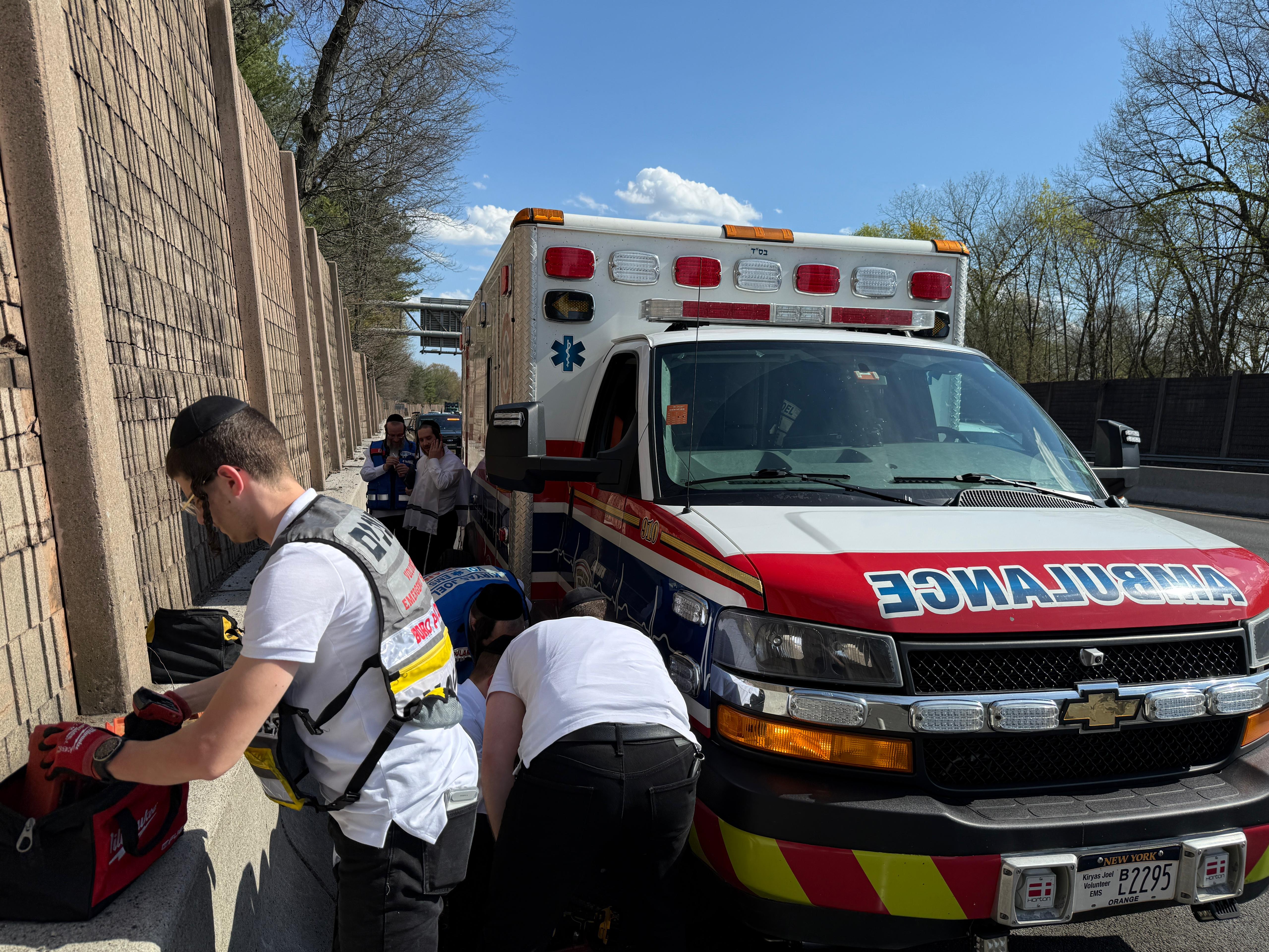 Chavivim members working on a blown tire of a KJ Hatzalah ambulance on the shoulder of Route 17 in New Jersey