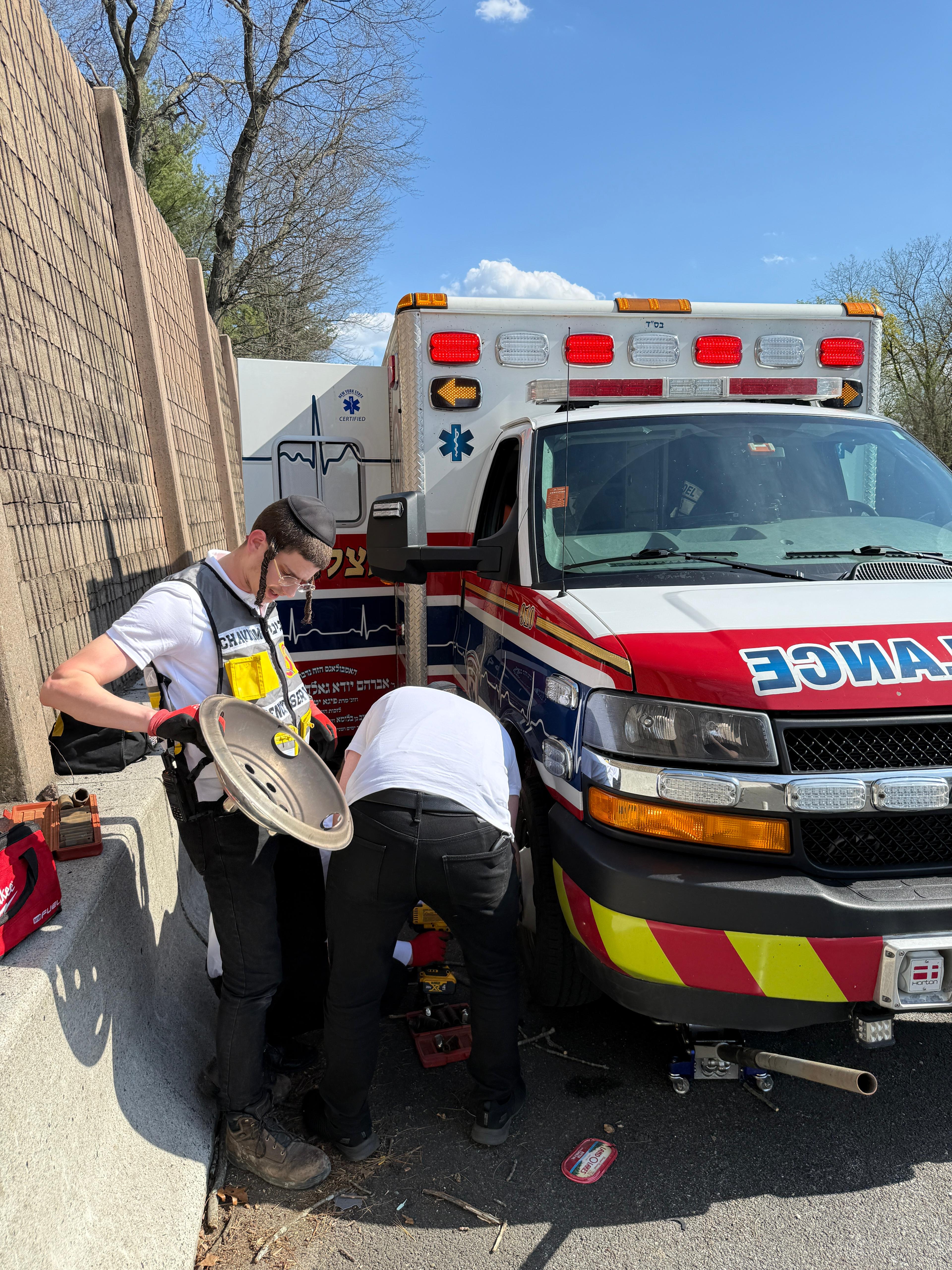 Chavivim members removing the blown tire from the KJ Hatzalah ambulance on Route 17