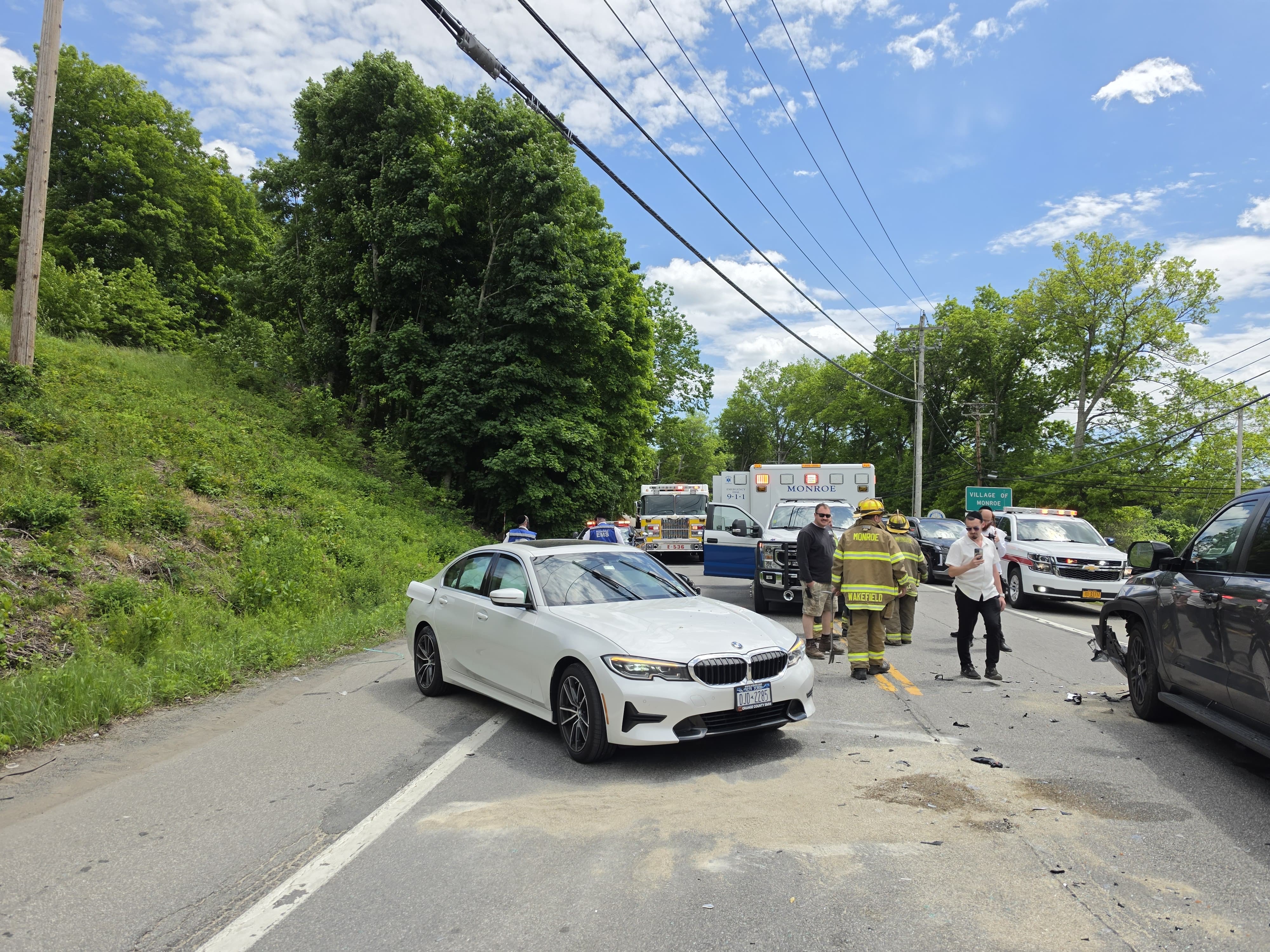 A white BMW on the shoulder with a Chavivim member directing traffic past the second crash on Orange and Rockland Road